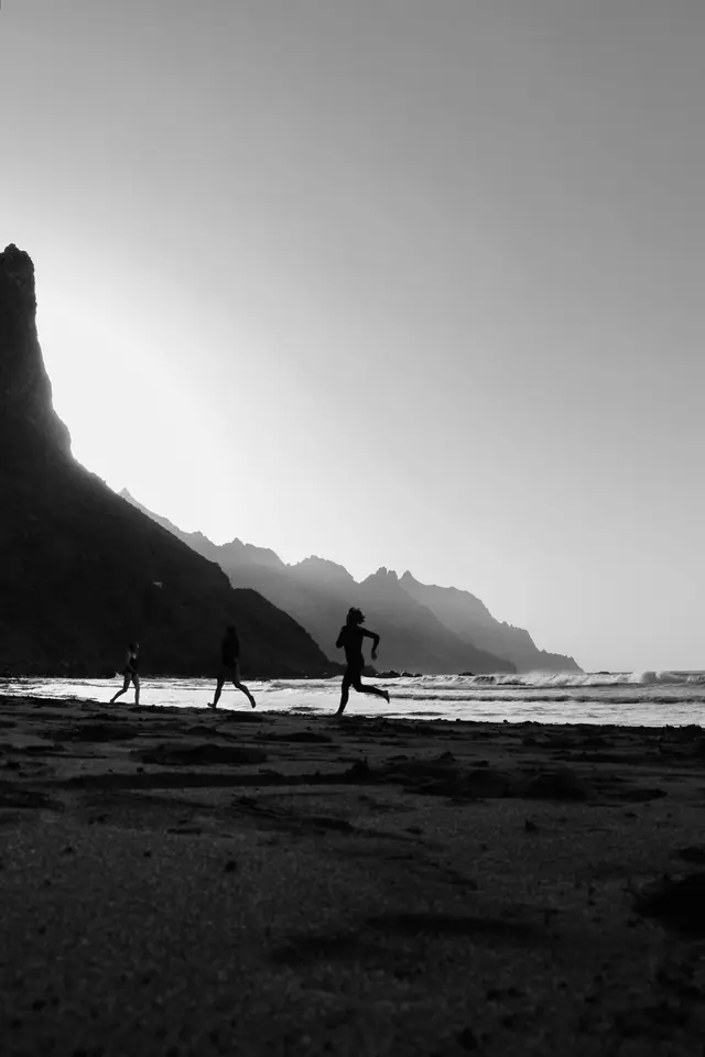 Coureurs en silhouette sur une plage à l'aube